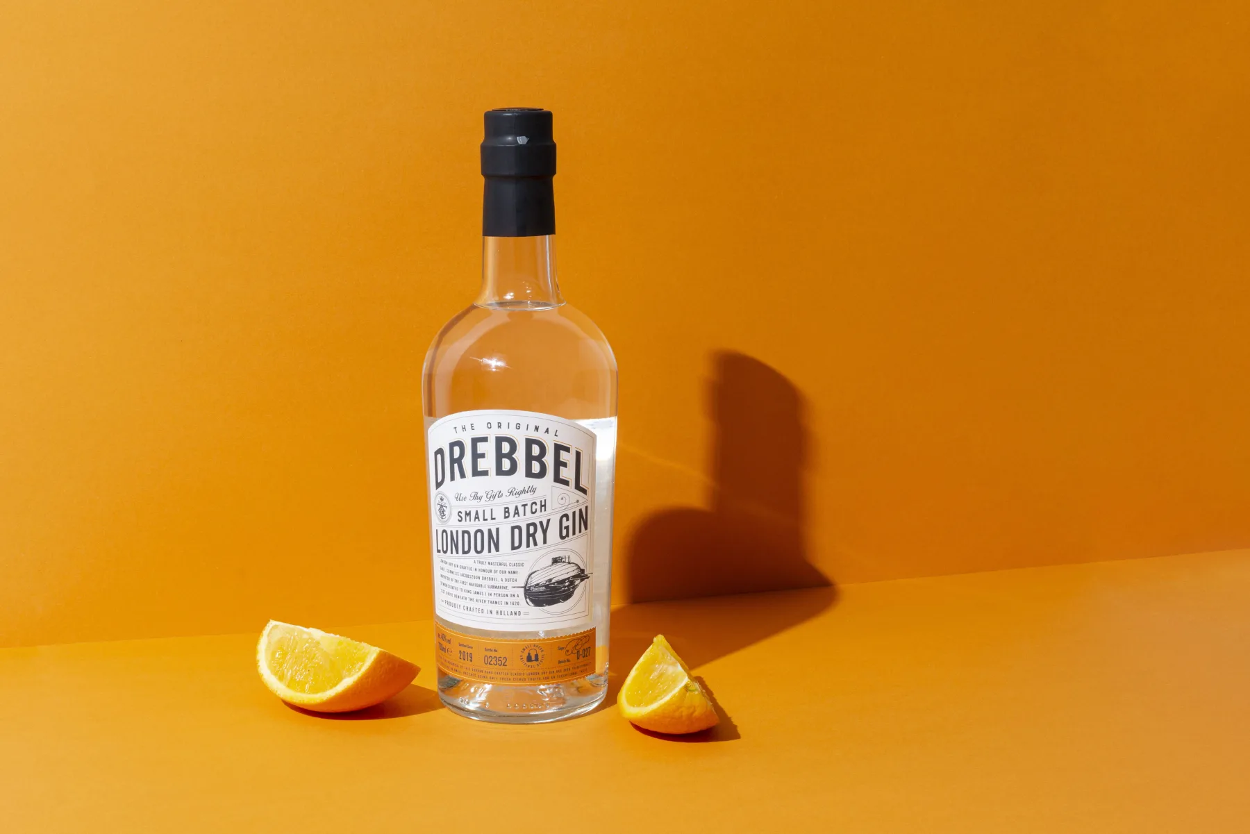 Drebbel Gin bottle on orange background with orange wedges